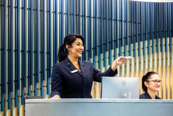 Female 房子前面 reception staff handing an access card to a visitor